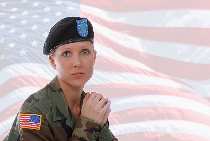 Military woman in a uniform in front of an American Flag