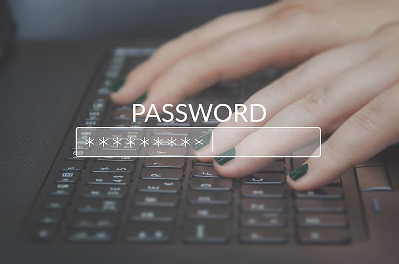 Woman's hands typing on a keyboard with the word password overlaying it